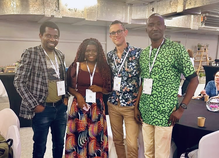 four smiling participants at the IAHR congress in Krakow, wearing their lanyards.