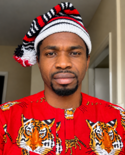 portrait of the author wearing a cap and tiger-pattern shirt.